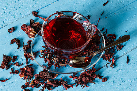 卡卡德红茶加干鲜花杯杯子白色叶子盘子草本植物红色花瓣桌子草本食物背景图片