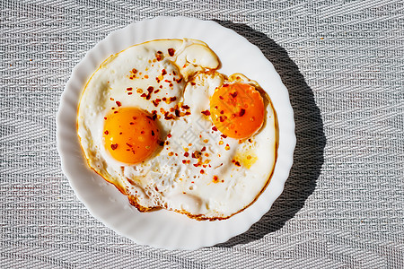 炸鸡蛋和辣椒煎饼放在盘子上胡椒烹饪营养木头圆形香料早餐食物辣椒蛋黄图片