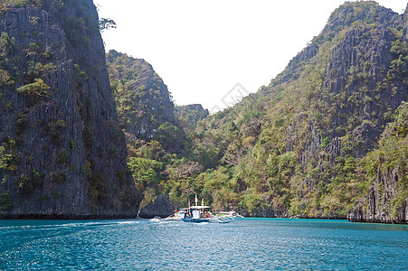 Kayangan湖水 石灰岩岩岩形成和船只天空旅行树木风景蓝色土地岩石编队运输石灰石图片