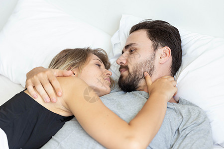 可爱的小情侣拥抱和睡在床上家庭枕头就寝女孩生活说谎微笑男性丈夫女性图片