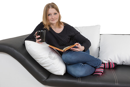 清凉的年轻女人正在沙发上读书图片