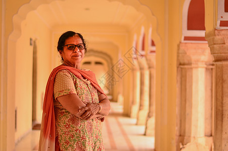 在印度拉贾斯坦邦斋浦尔市宫殿的走廊里 穿着传统西装的印度高级女士看起来很开心图片