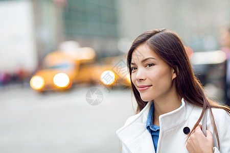 走在纽约市街道上等待汽车升降机拼车出租车的纽约女人 有黄色出租汽车汽车交通的亚裔年轻专家在背景中 混血儿图片