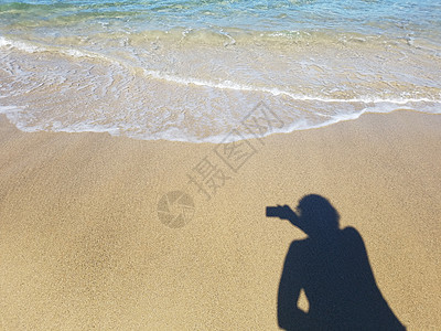 女人用阴影在沙里用水照像照片波浪沿海海洋相机女士海滩女孩女性图片