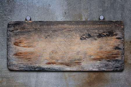 混凝土背景上的旧木标志图片