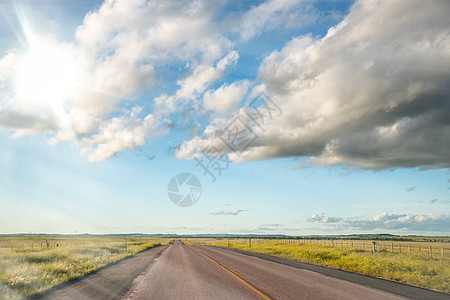 日落时横穿乡村的令人惊异的道路 蓝天空与木环运输阳光草地沙漠地平线田园自由小路旅行假期图片