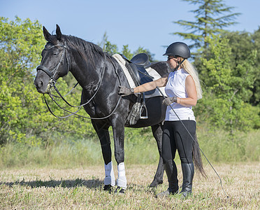 骑马的女童和女童骑术压痛黑色幸福头盔行为学女孩骑士训练动物图片