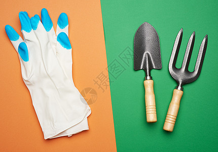 白橡胶手套和花园的铲子 草木 草叉图片