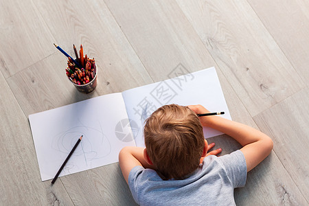 小男孩在房间里的地板上画画学校幼儿园地面铅笔玩具婴儿学习说谎技巧活动图片