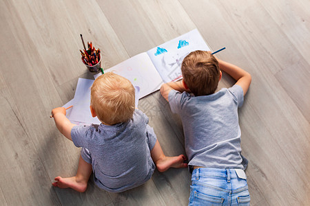 两个小男孩在他的房间里的地板上画画男生说谎乐趣玩具孩子活动教育绘画婴儿童年图片