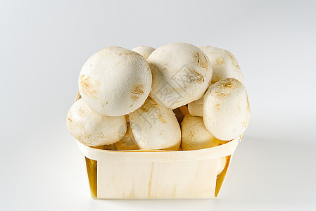 白蘑菇在浅色背景的木制篮子上打着冠军冠 与复制空间密不可分植物柳条蔬菜食物烹饪木头森林美食饮食团体图片