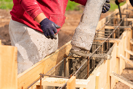 把水泥或混凝土用自动泵在基金会形式上铺设水泥或混凝土的建筑工人建设者房子基础设施固井项目备案金属混合器钢筋管道图片