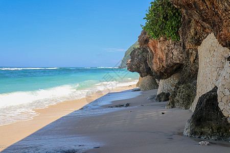 海浪冲向位于巴巴多斯沙滩海岸线上的一块黑色大岩石 并在空中飞溅 绿松石色的海浪冲进加勒比偏远热带岛屿的海岸图片
