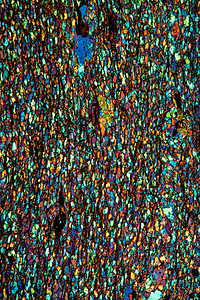 显微镜下Mikaschist矿物公司 100x水晶石头岩石调查科学蓝色火山岩红色矿物质粒状图片