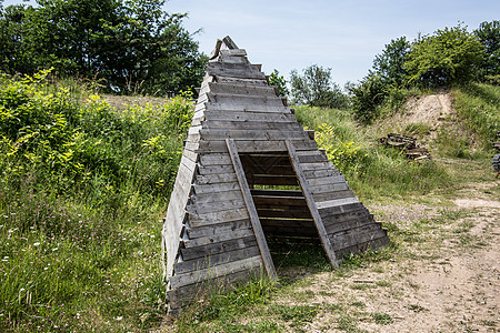 作为帐篷住宿的木金字塔棕色草地森林金字塔木板天空蓝色绿色小屋入口图片