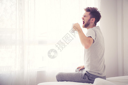 卧室概念的生活方式肖像 男人举着一杯咖啡活力早餐饮料幸福房子睡衣男性成人房间闲暇图片