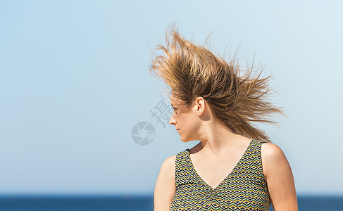 一个穿着绿裙子的中年金发女郎 身穿绿衣 头发在风中颤抖图片