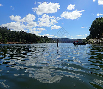 河水中的浮泉 有船和云多云树木池塘溪流娱乐图片