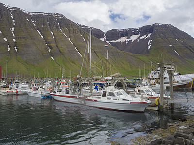 冰岛 西码头2018年6月25日 Isafjordur Isafjordur港夏季视图 有渔船船和美丽的绿雪覆盖山脉和悬崖 云层图片