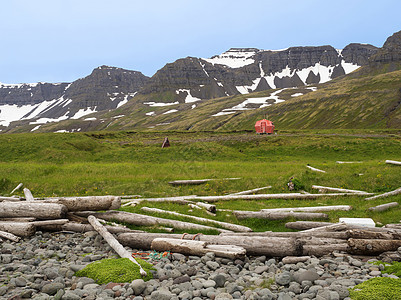 Hloduvik难民营地和红色紧急避难所小屋站在草草原上 观察雪鳕山悬崖 石块和西码头 冰岛图片