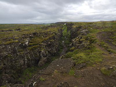 冰岛廷韦利尔国家公园的中大西洋海脊与步行路线及徒步旅游者之间北美-欧洲低地裂缝图片