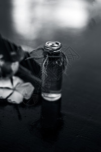 草药和植物精华 或由罗斯马林斯在木质表面的玻璃瓶中摘制出来的浓缩物 也称为玫瑰花温泉草本绿色瓶子治疗疗法香味按摩玻璃芳香图片