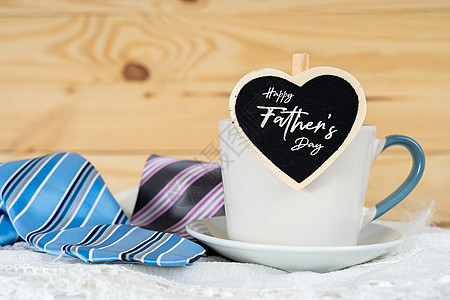 父亲节快乐背景概念与一杯茶 黑色心形和蓝色和粉色领带在木制背景上 带有文本复制空间微笑父母孩子胡子卡片手工展示节日杯子作品图片