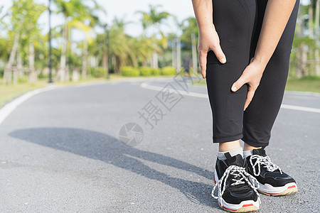 亚裔妇女跑在r上时用手握住膝盖受伤痛苦肌肉疼痛女孩运动伤害跑步赛跑者治疗女士图片