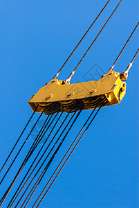 蓝色天空上的大型黄滑轮和电缆组装图片