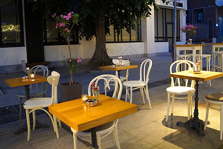 晚上在Varna中央街道上街咖啡厅的空桌椅上放着蜡烛图片