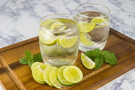 从柠檬中冷饮 在木杯上用水玻璃切成碎片饮食绿色玻璃木头水果健康稻草食物草本植物饮料图片