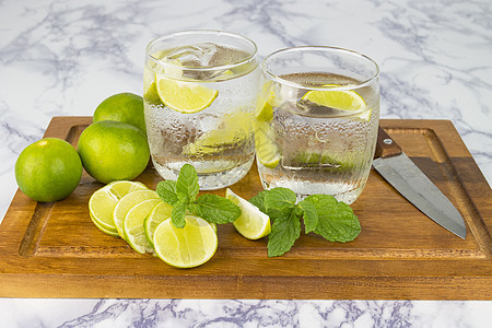 从柠檬中冷饮 在木杯上用水玻璃切成碎片饮食玻璃草本植物稻草水果食物健康绿色饮料木头图片