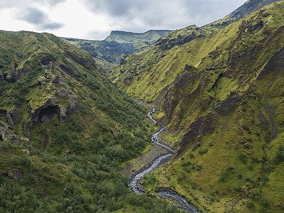 高地和大草原的景观 绿苔覆盖着岩石和山丘 弯曲河流峡谷 冰岛 费姆沃尔杜哈尔斯登山足迹 夏季多云日溪流公园崎岖旅行河床远足蓝色旅图片