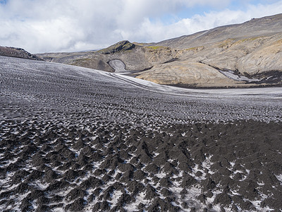 漫步的地貌景观 由黑色熔岩灰丘和火山山覆盖的近距离雪雪图片