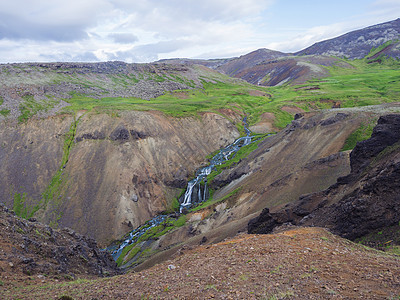 Reykjadalur山谷 有温泉河 青草草原 岩石和山丘以及地热蒸汽 南冰岛靠近Hveragerdi市 夏日清晨 蓝天天空黄金图片