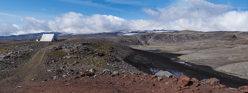 泛红和黑火山冰岛景观 在的山丘棚屋经过远足路线和冰川火山峰图片