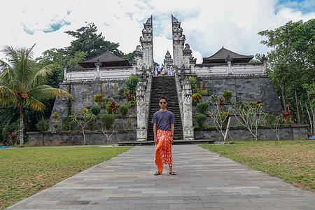 美丽的寺三座石梯背景下的年轻男子游客 与台阶的夏天风景到寺庙 Paduraksa 门户标志着中间圣地的入口楼梯建筑文化崇拜地标历图片