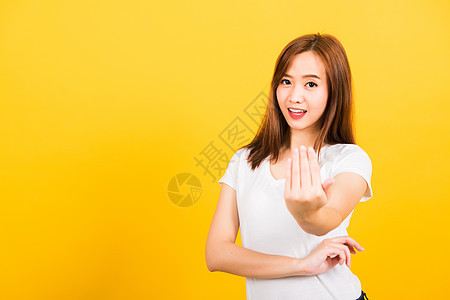 妇女少女微笑站着 穿着白色T恤 手举手棕榈呼唤微笑广告手势女孩女性手臂牙裔黄色图片