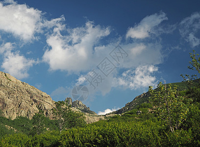 山地风景绿色山谷 有藻类洗涤剂 烟囱 白云和蓝天空图片