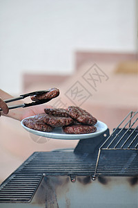 松开的牛排被放在烤架上的盘子上烹饪牛肉红色午餐营养猪肉食物美食棕色燃气图片