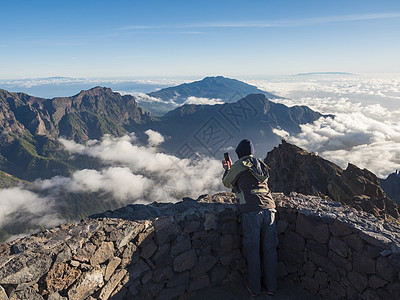 从西班牙加那利群岛拉帕尔马岛山峰看到的火山口国家公园拍照的男游客图片