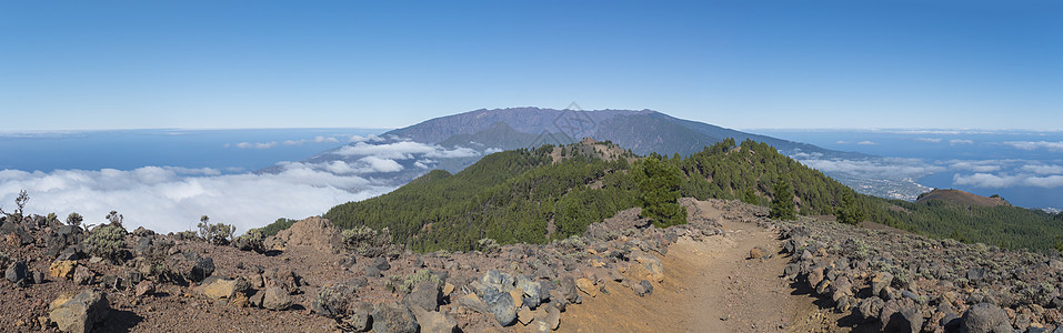 在路径的远足径上 可以欣赏到火山景观的全景 包括郁郁葱葱的绿色松树 五颜六色的火山和白云 拉帕尔马岛 加那利群岛 西班牙 蓝天背图片