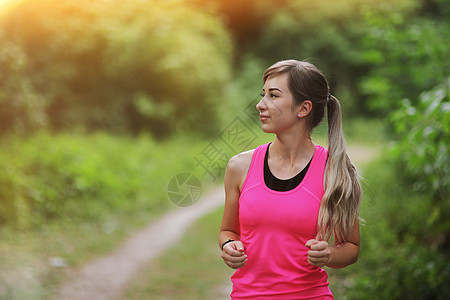 年轻的健身女子在早晨的森林小径上奔跑 健康的生活阳光身体肌肉训练赛跑者运动跑步速度运动装生活方式图片