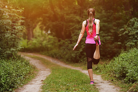 年轻健身女子在跑进森林之前暖和起来 然后才能在森林中奔跑阳光黑发身体公园耐力生活方式健康慢跑者运动员肌肉图片