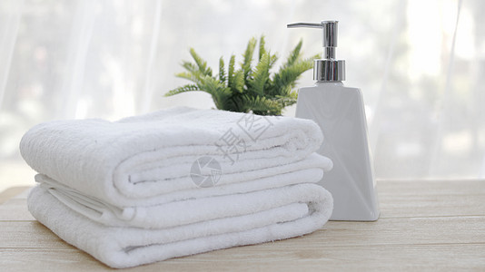 放在浴室桌上的洗手间桌边上 装瓶液肥皂和白毛巾洗澡瓶子棉布房间液体桌子白色产品淋浴身体图片