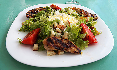凯撒沙拉加鸡肉和奶酪 在一个大白盘子上图片