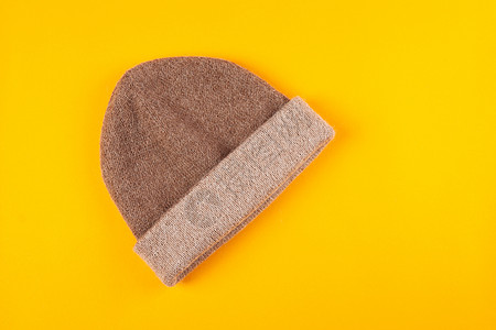 黄色背景的Beige编织帽婴儿季节羊绒羊毛毛衣天气针织羊驼帽子衣服图片