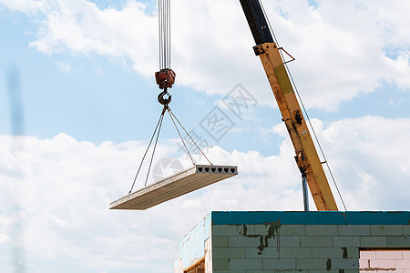 建筑工人在建筑施工现场安装混凝土楼板面板货物框架天花板平板地面建设者工人起重机吊钩工程图片