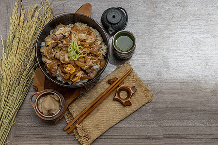 配有蛋和洋葱的日本猪饭碗唐布里美食蔬菜文化午餐绿茶干花筷子盖饭猪肉植物图片