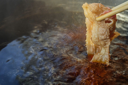 手用筷子 在热锅汤上捡生猪肉食品美食食物库存餐厅静物猪肉火锅烹饪黑豚图片